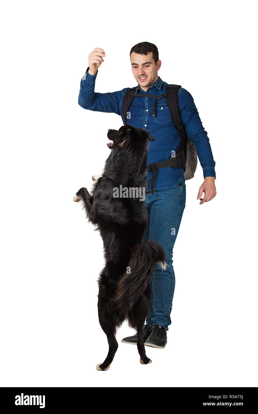 Junger Mann geben den Befehl zu seinem Border Collie Hund auf zwei Pfoten zu erhalten, zeigt mit der Hand darauf zu achten, auf weißem Hintergrund. Eigentümer der Bahn hi Stockfoto