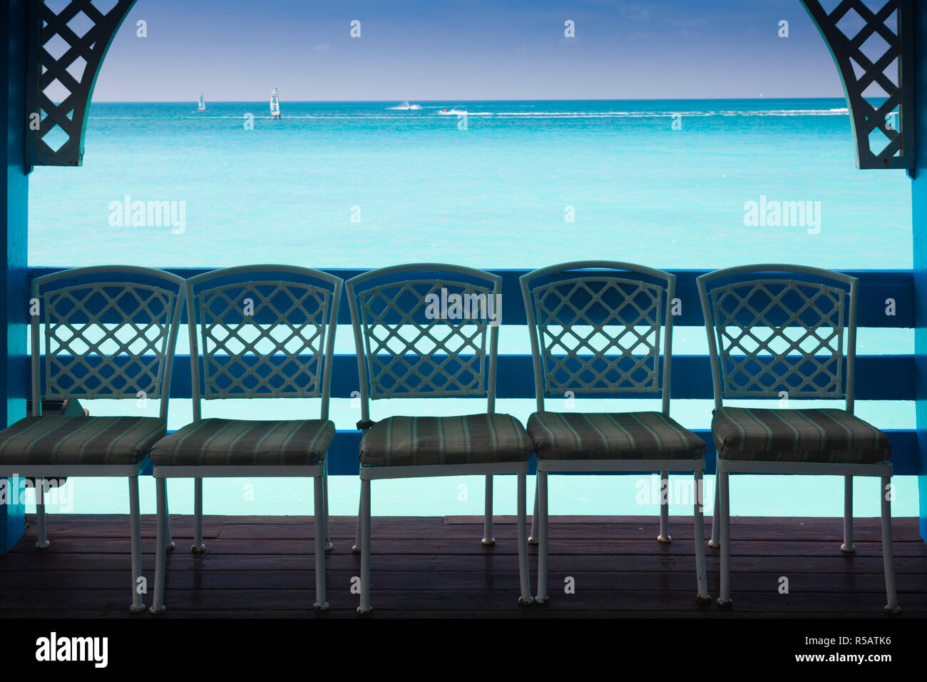 Antigua und Barbuda, Antigua, Dickenson Bay, Strand pier Pavillon Stühle Stockfoto