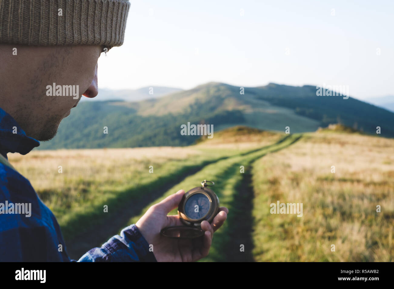 Mann mit Kompass in der Hand auf den Bergen unterwegs. Travel Concept. Landschaftsfotografie Stockfoto