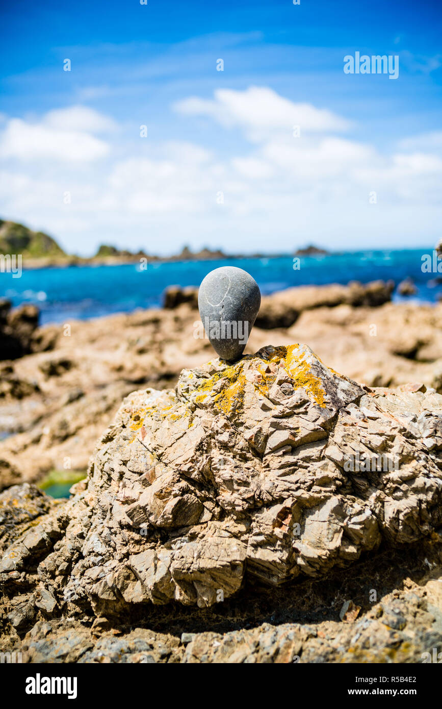 Stein in Balance auf einem Felsen am Meer (Stein balancing). Stockfoto