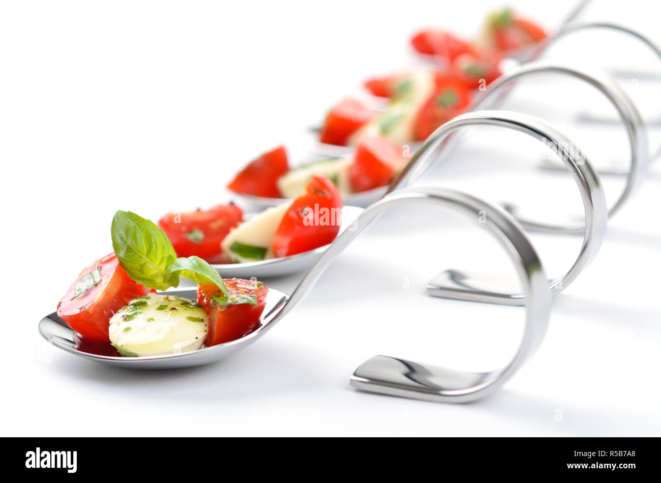 Caprese: Cherry-Tomaten, Mozzarella, Basilikum Olivenöl und Kräutern auf Party Löffel Stockfoto