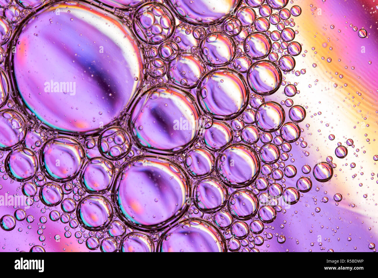 Zusammenfassung Hintergrund der Nahaufnahme Detail in pflanzlichem Öl Tröpfchen/Blasen auf der Oberfläche des Wassers mit einem bunten Hintergrund Stockfoto