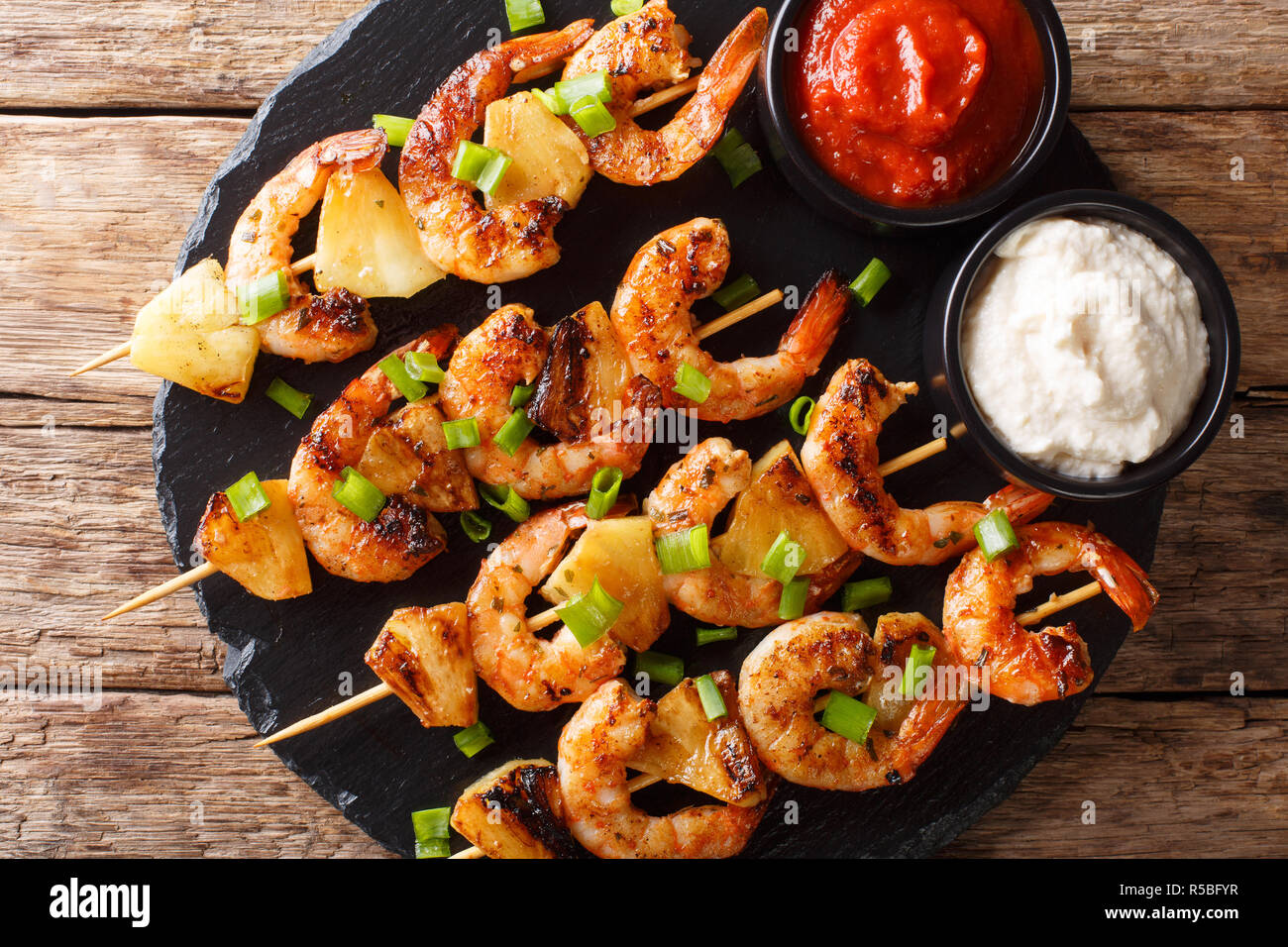 Würzige Garnelen Kebab mit Ananas mit zwei Saucen in der Nähe serviert - auf den Tisch. horizontal oben Ansicht von oben Stockfoto