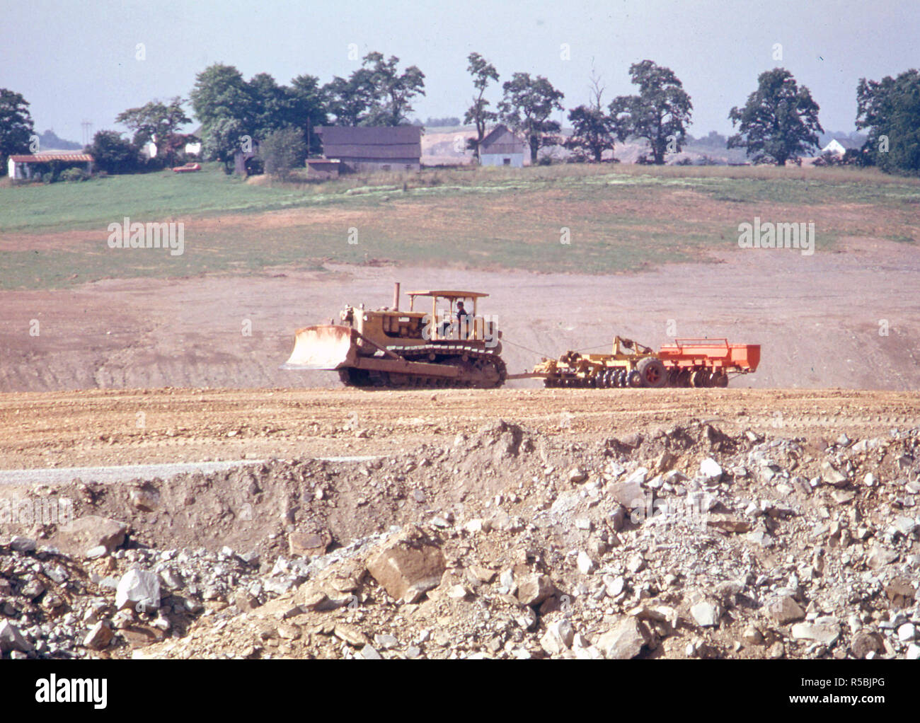 Bulldozer Ziehen einer Sämaschine über Recontoured, Land, auf dem zuvor Hatte Streifen durch die Kohle Unternehmen an der Route 800 in der Nähe von Edgewater Park, Ohio abgebaut und Barnesville. 07/1974 Stockfoto
