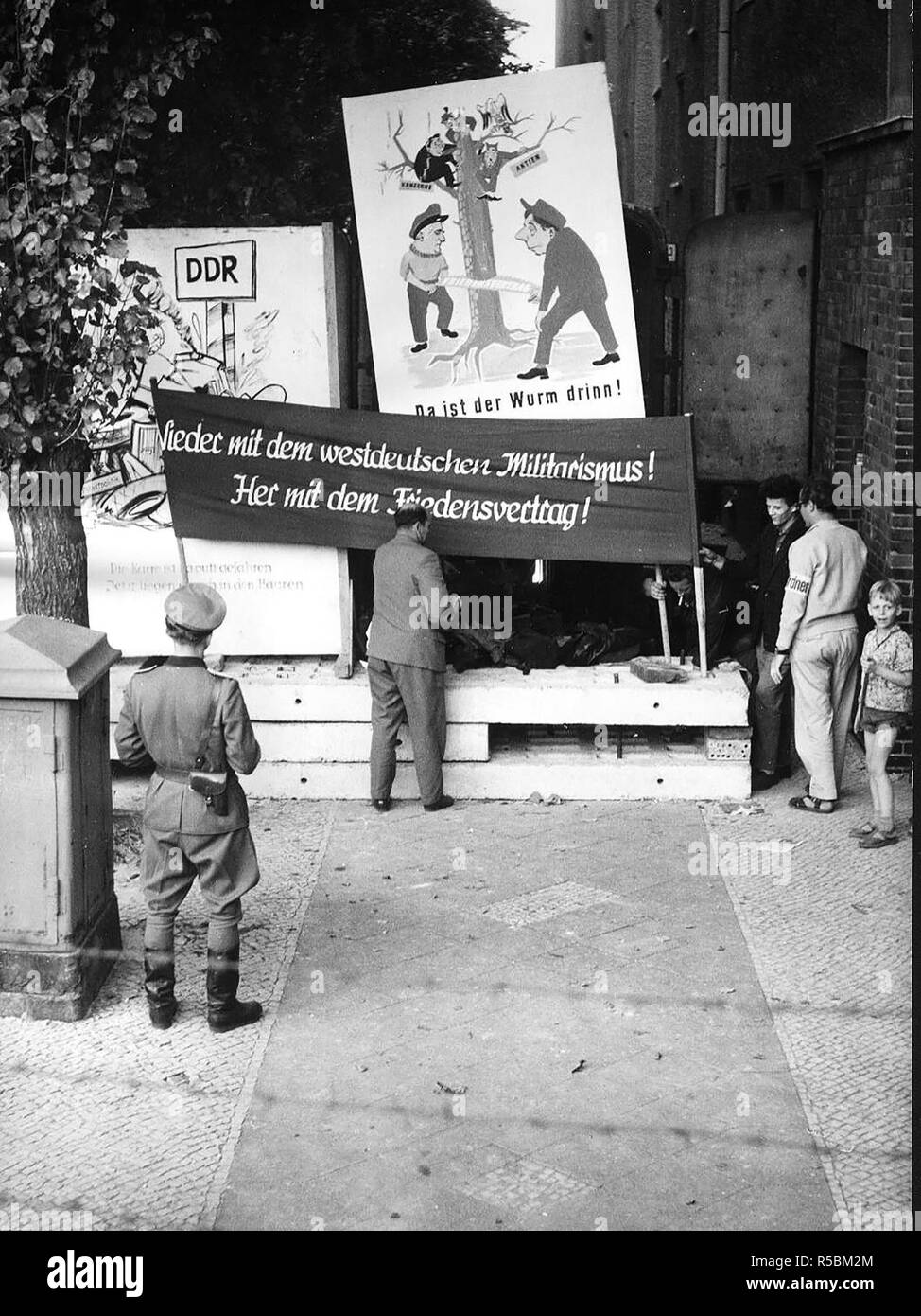 9/21/1961 - Banner sagt: "Weg mit Westdeutschen Militarismus! Geben Sie uns einen Friedensvertrag!" Die Bewohner des Ostens Berlin Häuser, die in der Nähe von der Grenze an der Wand werden evakuiert Stockfoto