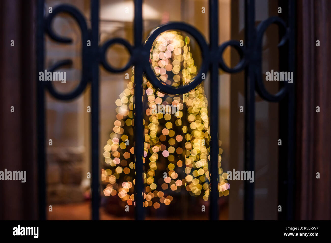 Abstrakte Urlaub verschwommenen Hintergrund. Unscharfer Hintergrund mit leuchtenden Weihnachtsbaum hinter Gittern von Fenster Stockfoto