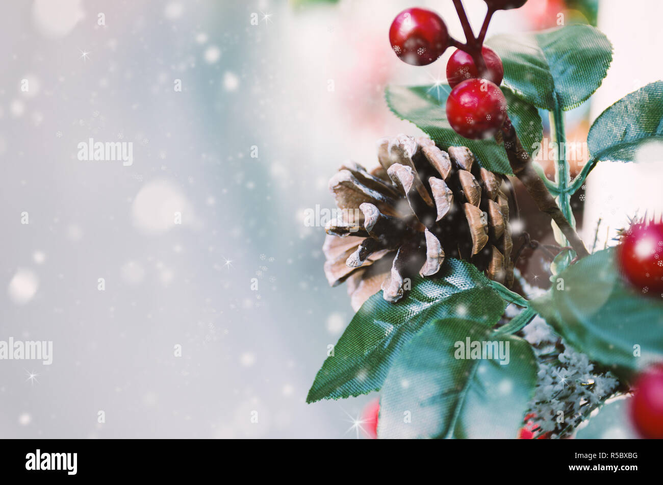 Winterurlaub Postkarte - Urlaub Hintergrund mit Weihnachtsdekor und Schnee. Zusammensetzung von Pine Cone, rote Beeren, grüne Blätter. Neues Jahr Gruß c Stockfoto