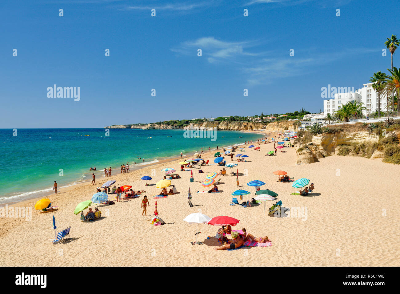 Armacao de Pera Strand mit Sonnenschirmen, vor dem Holiday Inn Hotel Stockfoto