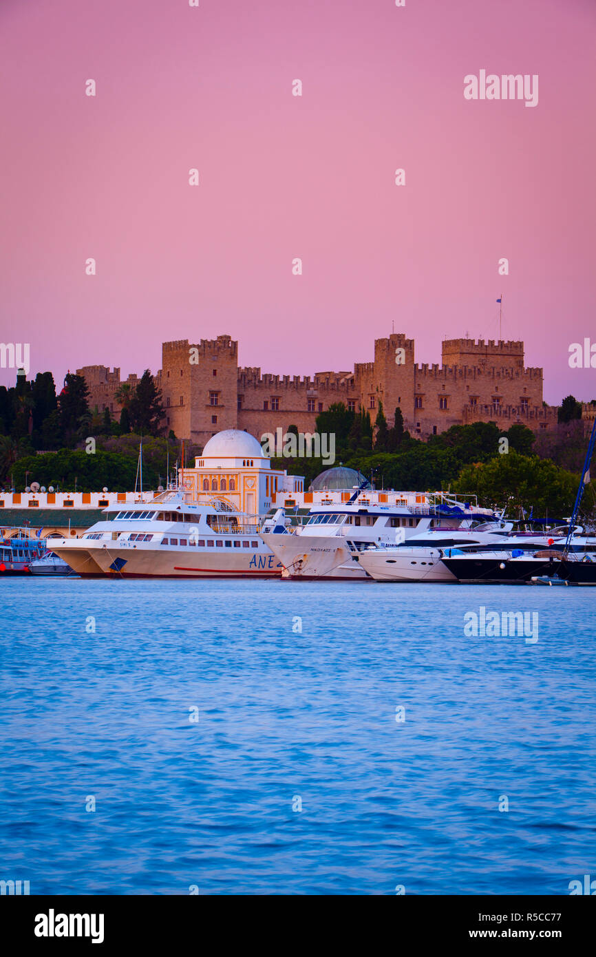Palast der Großmeister & Mandraki Hafen leuchtet in der Dämmerung, Rhodos Stadt, Rhodos, Griechenland Stockfoto