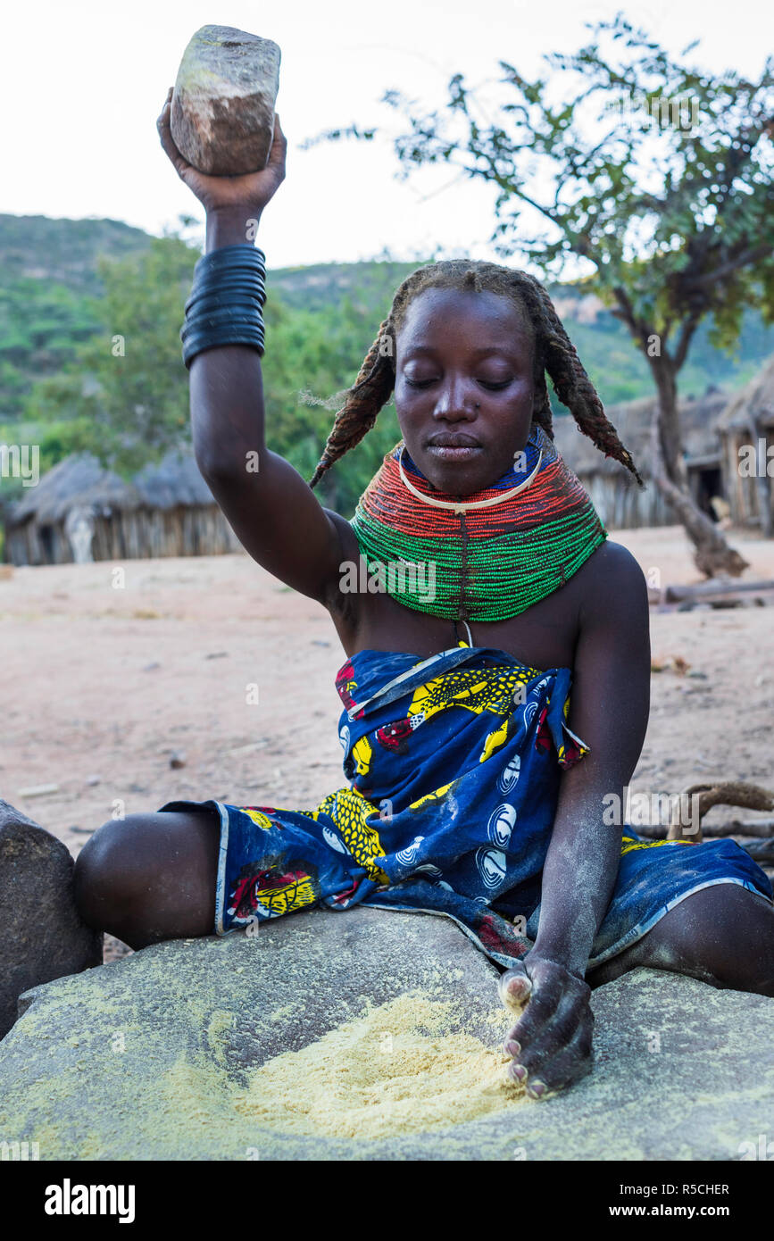 Muila Frau Zertrümmern der Kork von einem Baum mit einem Felsen eine Paste für die traditionelle Frisur, die Frauen zur Vorbereitung nutzen. Stockfoto