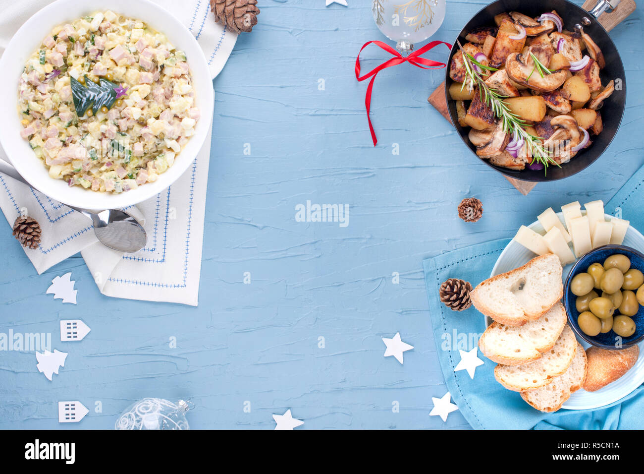 Verschiedene traditionelle Speisen für Tabelle zum Neuen Jahr. Russischer Salat und Bratkartoffeln mit Pilzen. Ansicht von oben. Freien Speicherplatz für eine Kopie des Textes Stockfoto