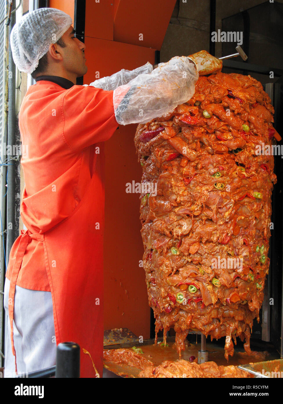 Mann Zubereitung Hähnchenfleisch auf einer drehbaren Spieß für die Kebabs. Beyoglu, Istanbul, Türkei Stockfoto