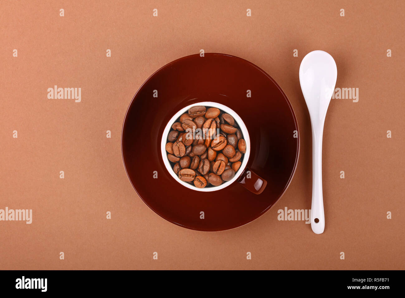 Braune Tasse geröstete Kaffeebohnen auf Pergament Stockfoto