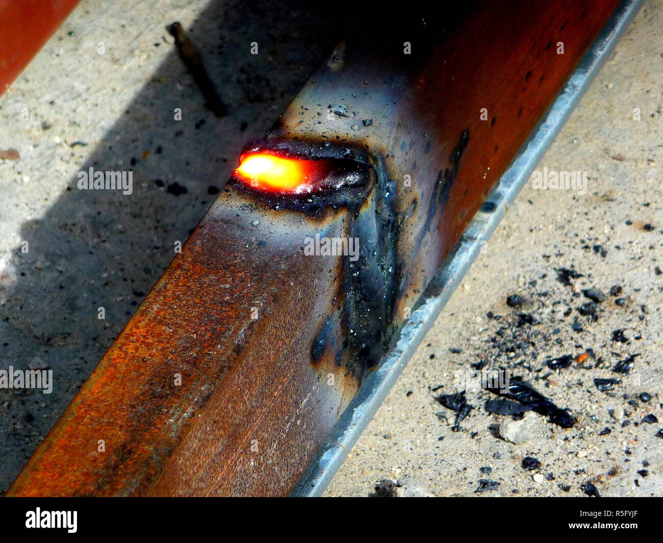 Heiße Funken des Feuers von Stahl Schneidemaschinen wenn Männer mit dem Schleifer disc Stahl oder der Sauerstoff Schweißarbeiten an Stahl schneiden Teile zusammen zu schweißen Stockfoto