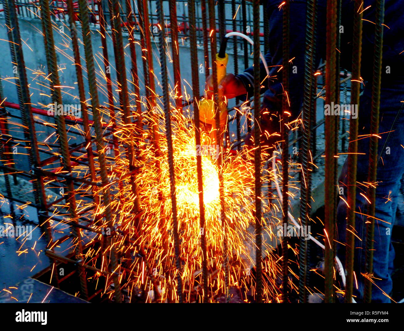 Heiße Funken des Feuers von Stahl Schneidemaschinen wenn Männer mit dem Schleifer disc Stahl oder der Sauerstoff Schweißarbeiten an Stahl schneiden Teile zusammen zu schweißen Stockfoto