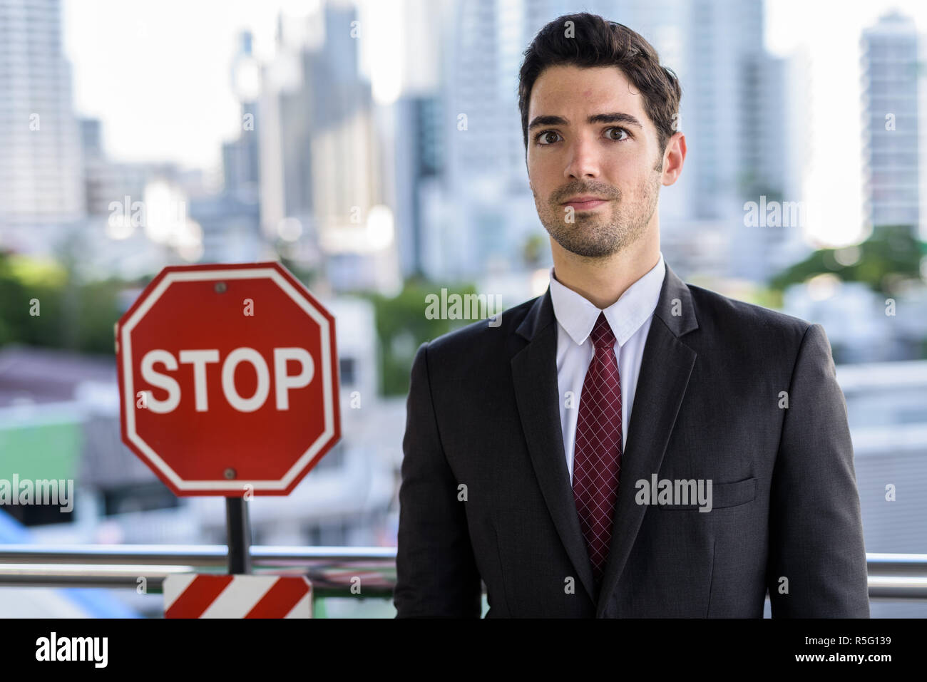 Portrait der junge Geschäftsmann neben STOP-Schild Stockfoto