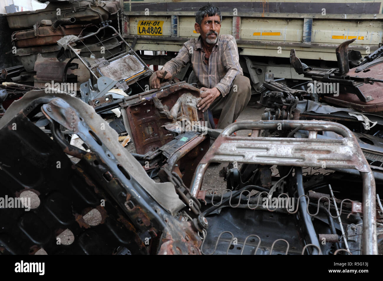 Ein Mann in der Diebe Markt oder Chor Bhendi Bazar Bazar in der Gegend von Mumbai, Indien, Demontage Auto Teile für den Weiterverkauf Stockfoto