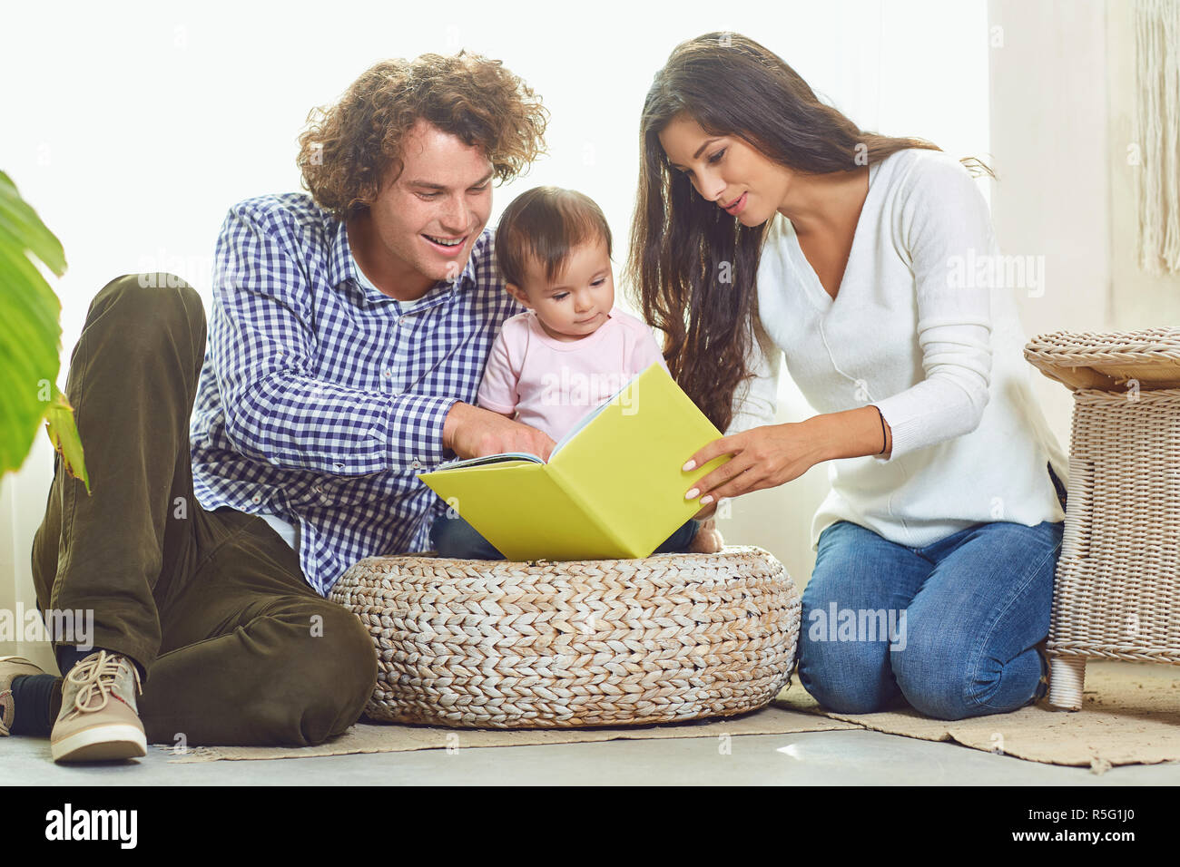 Mutter, Vater und Kind liest ein Buch zu Hause Stockfoto