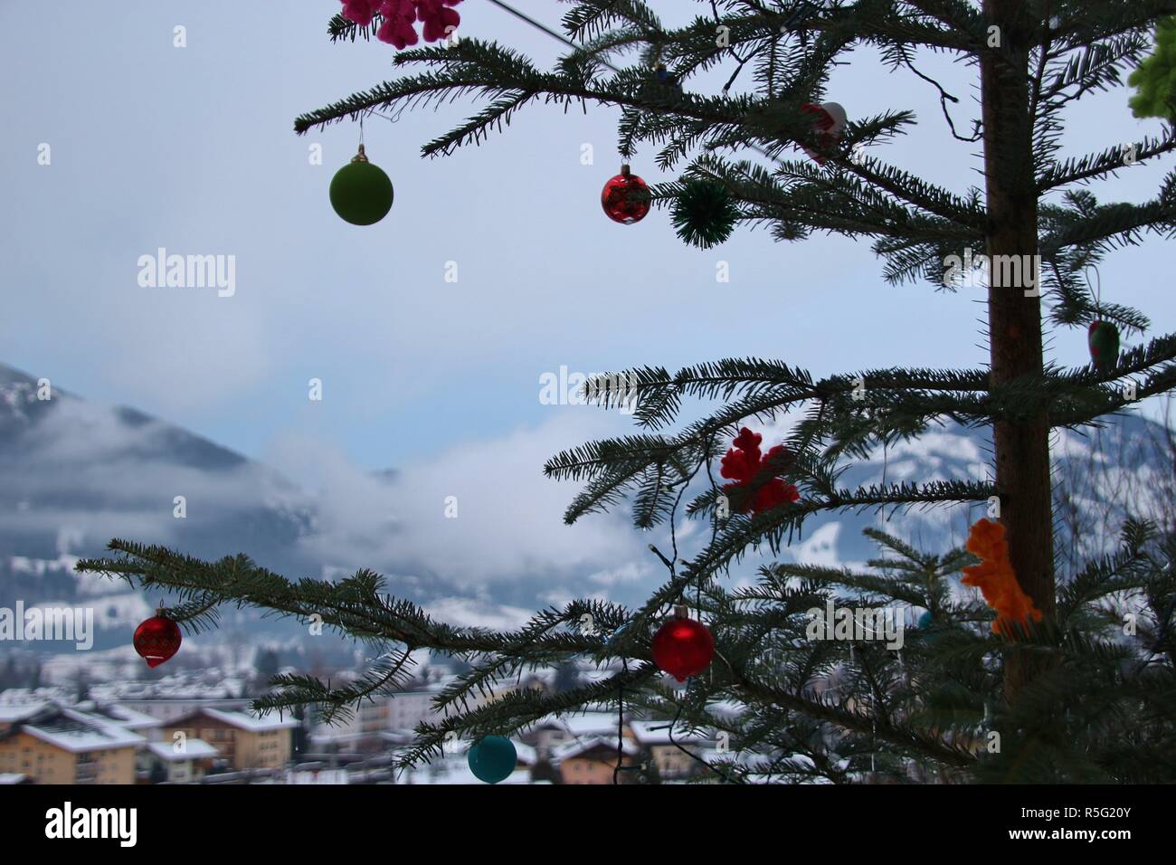 Weihnachten in den Bergen: eine Tanne in der Natur, mit Weihnachtsdekoration. Blick auf Schuttdorf Bezirk und die Berge. Zell am See, Österreich, Europa. Stockfoto