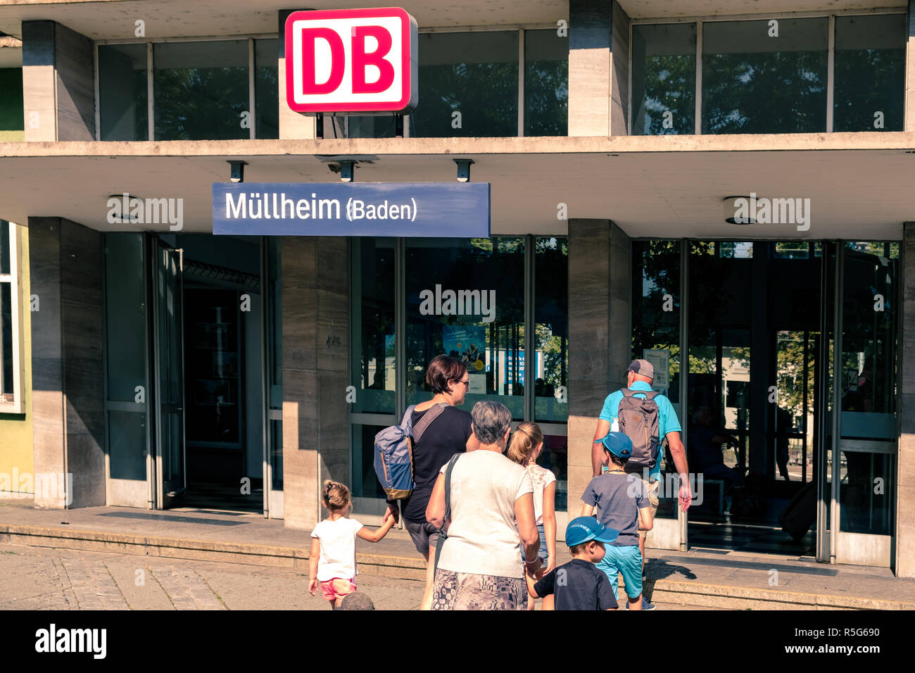 Mullheim, Baden-Württemberg, Deutschland - 30. JULI 2018: Familie, Großeltern, Mutter und Kinder, Eingabe des Mullheim Bahnhof mit Rucksäcken. Stockfoto