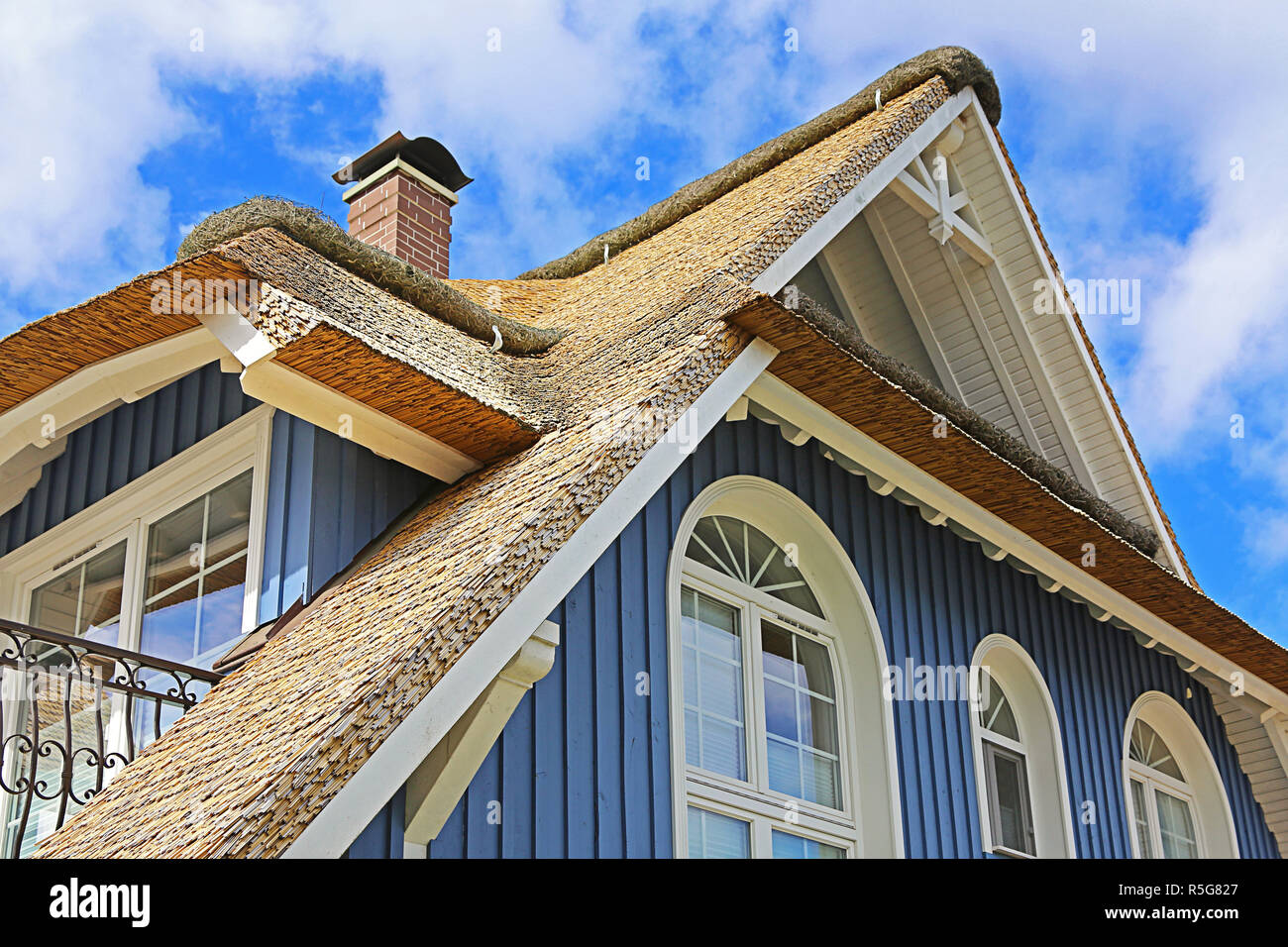 Blaue Haus an der Ostsee mit Reetdach Stockfoto