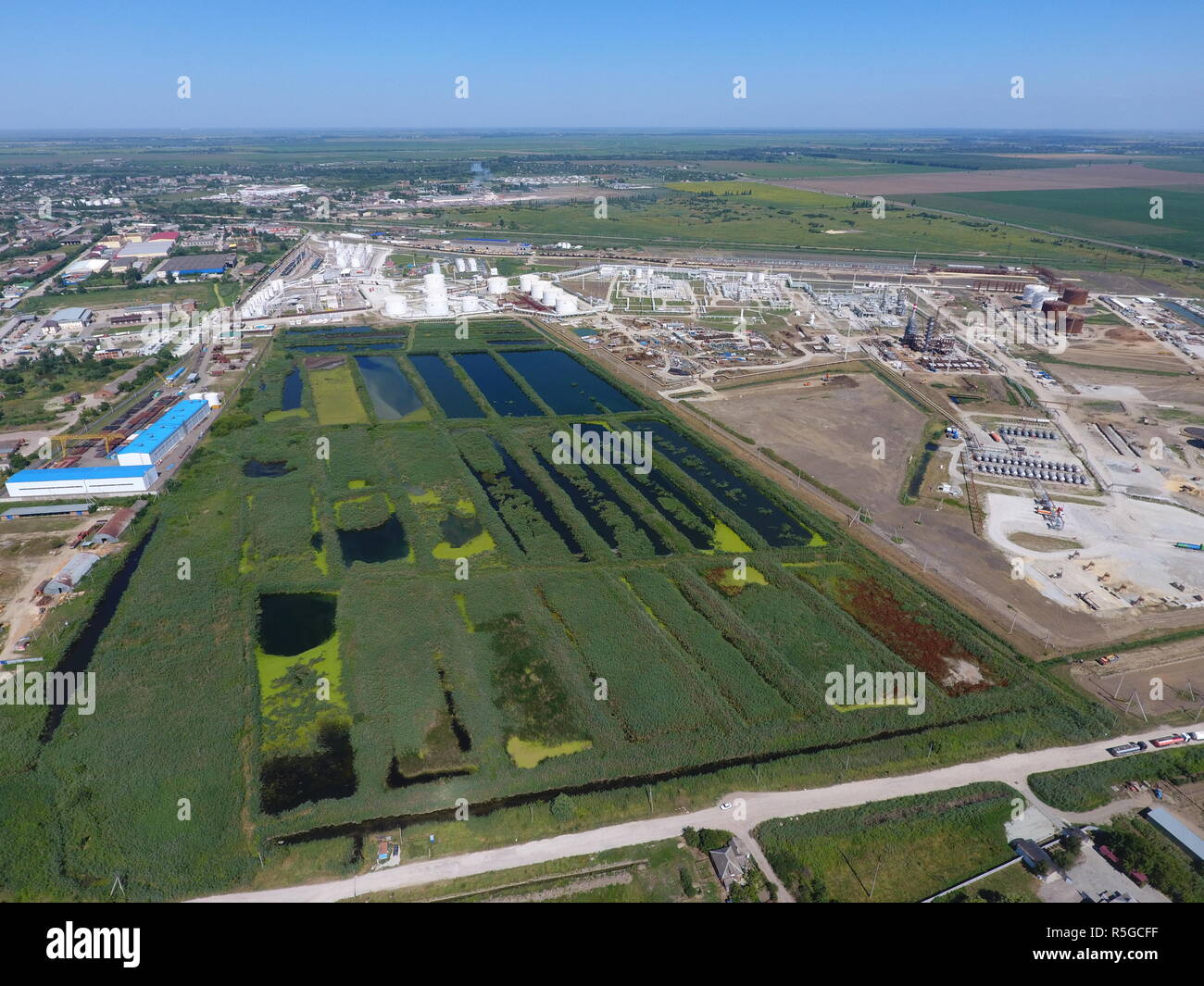 Die Kläranlage in Slavjansk-auf Kuban. Wasser für die Abwasserbehandlung in einer kleinen Stadt. Helle Schilf am Ufer des Wassers Stockfoto