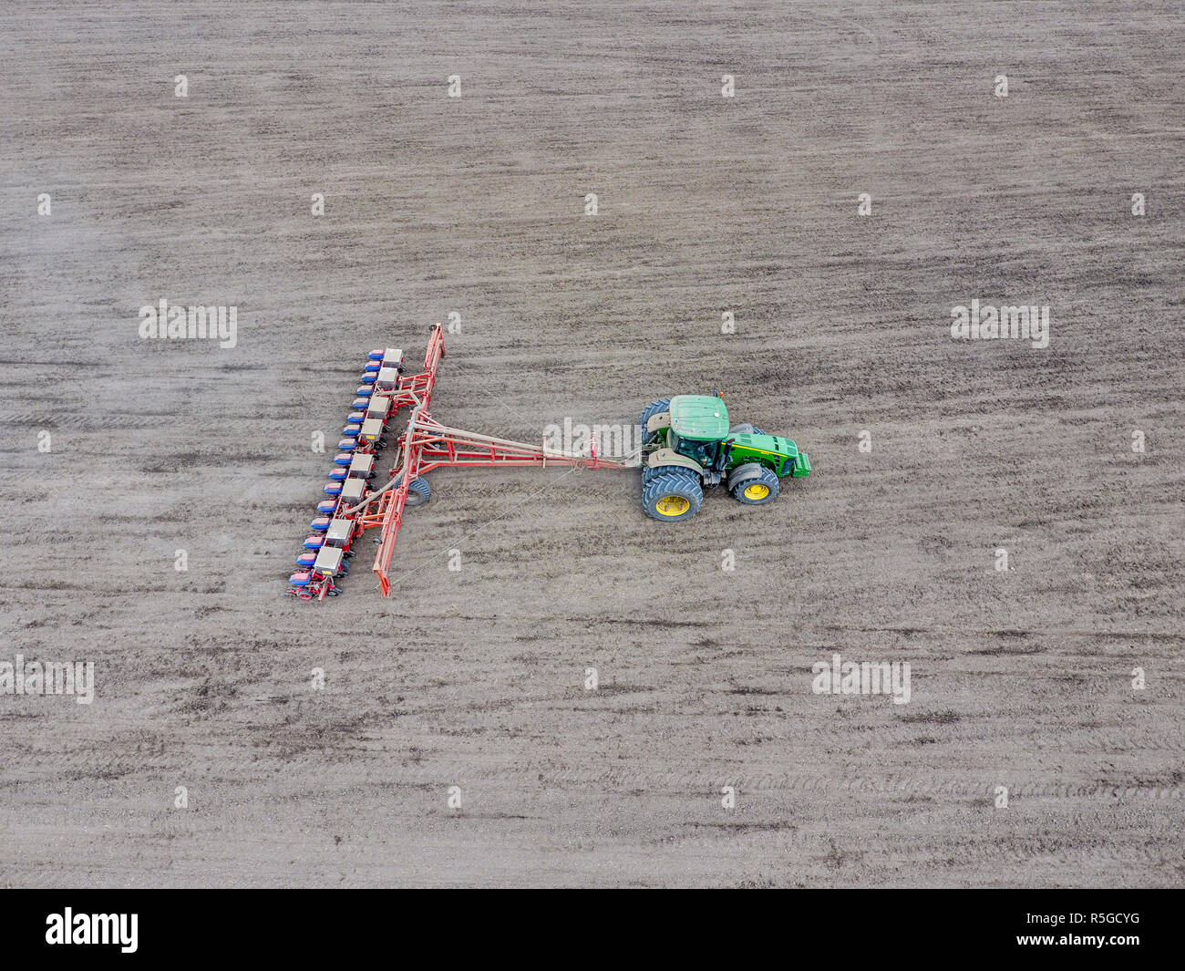 Die Aussaat von Mais. Traktor mit einer Sämaschine auf das Feld. Mit einer Sämaschine für die Anpflanzung von Mais. Stockfoto