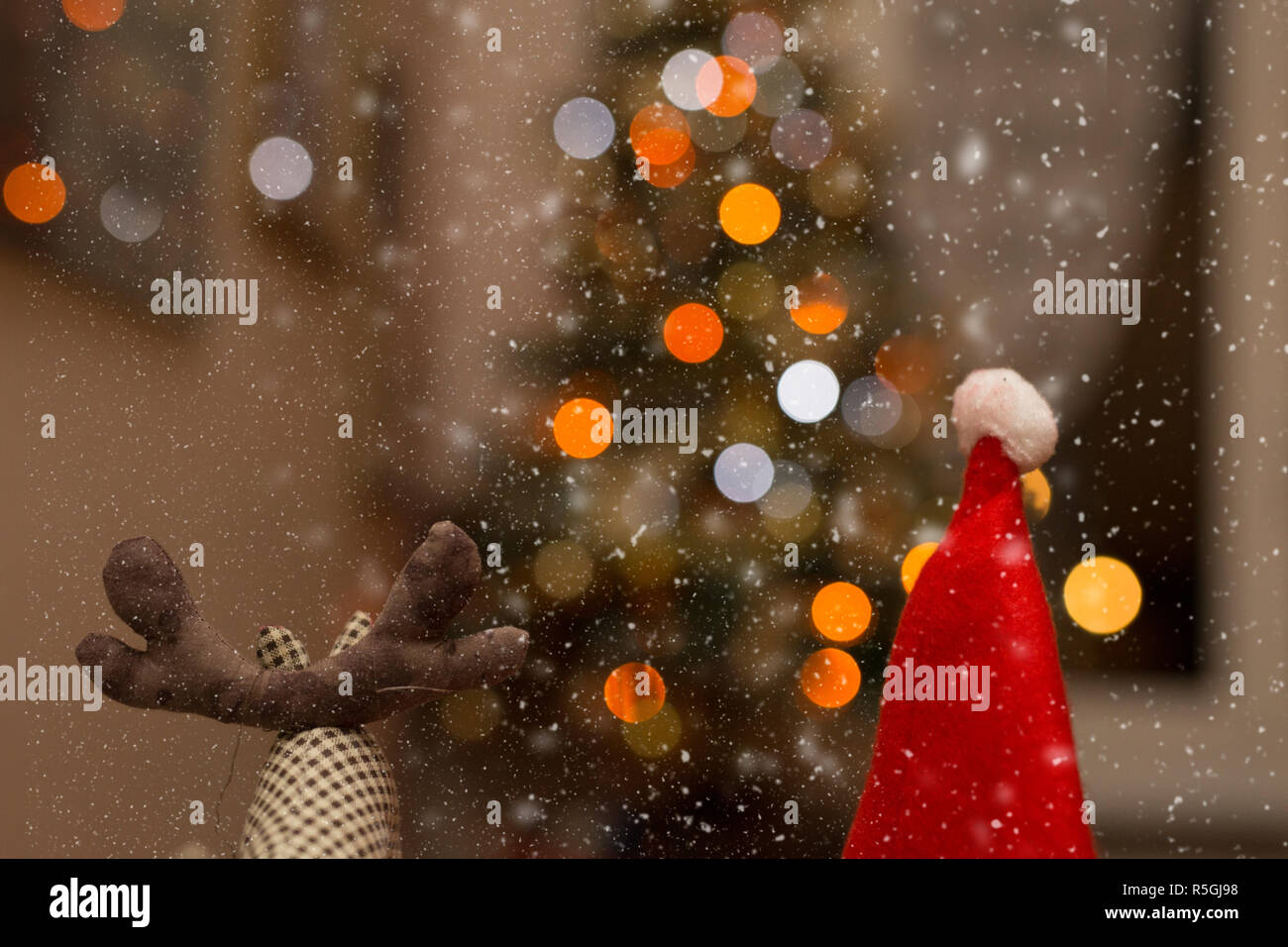 Rudolf und Santa Claus unter dem Schnee mit Licht im Hintergrund Stockfoto