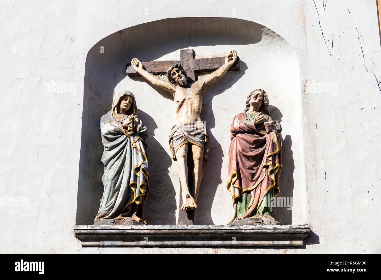 Trier, Deutschland. Christus am Kreuz mit der Jungfrau Maria und der hl. Johannes in St. Gangolf Kirche Stockfoto