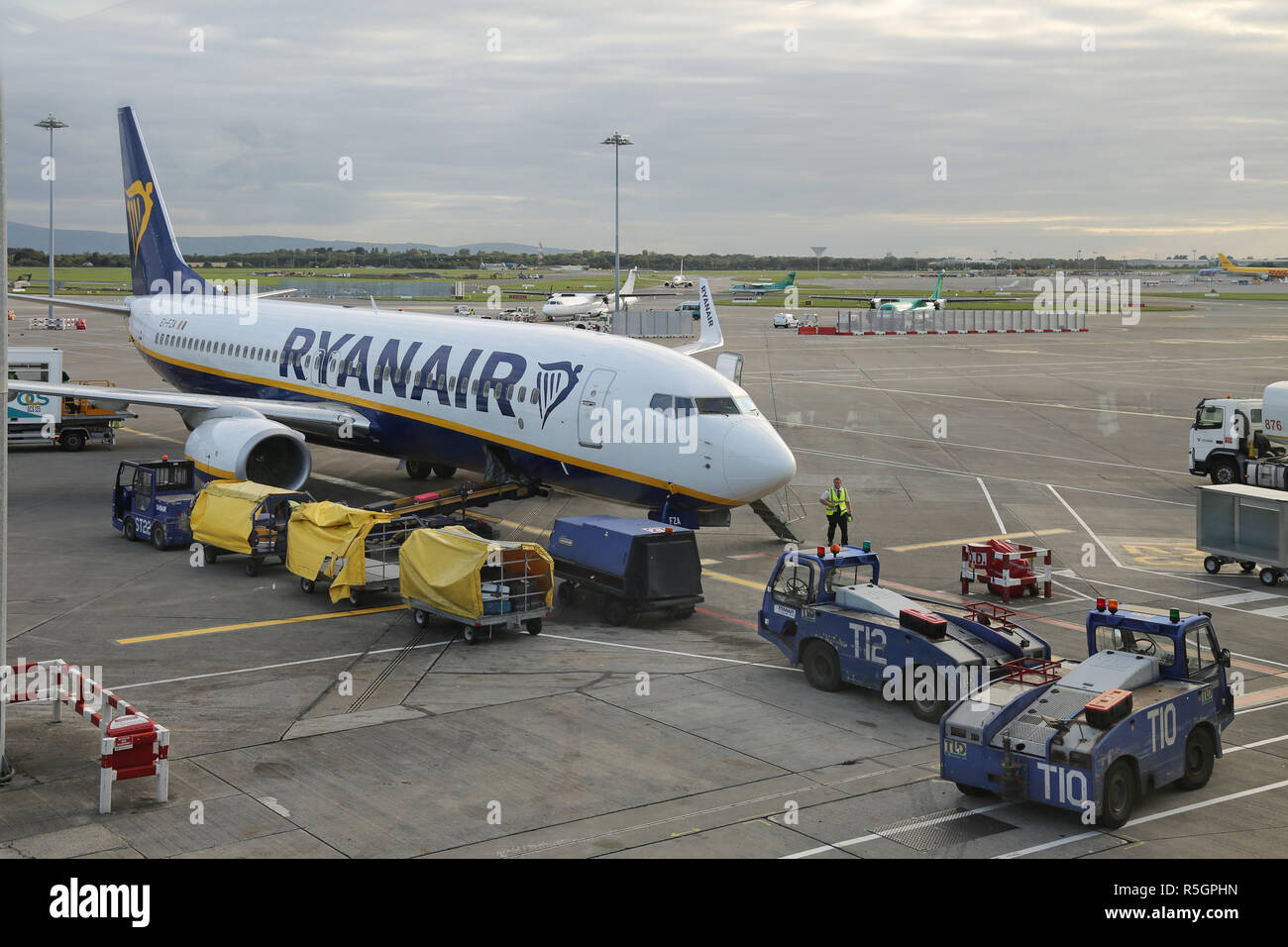Eine Ryanair Boeing 737 Parks auf dem Vorfeld des Internationalen Flughafen Dublin, Irland, Klemme 2. Zeigt Gepäck laden und Service Fahrzeuge. Stockfoto