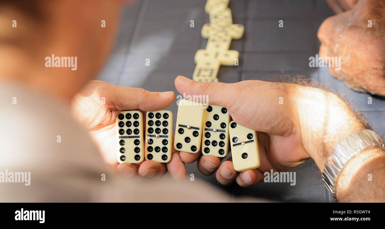 Pensionierte ältere Mann spielt Domino Spiel mit Freunden Stockfoto