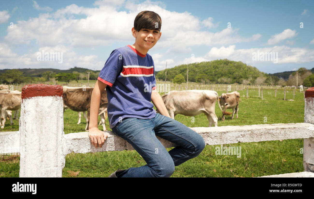Portrait von Happy Boy im Bauernhof mit Kühen in Ranch Stockfoto