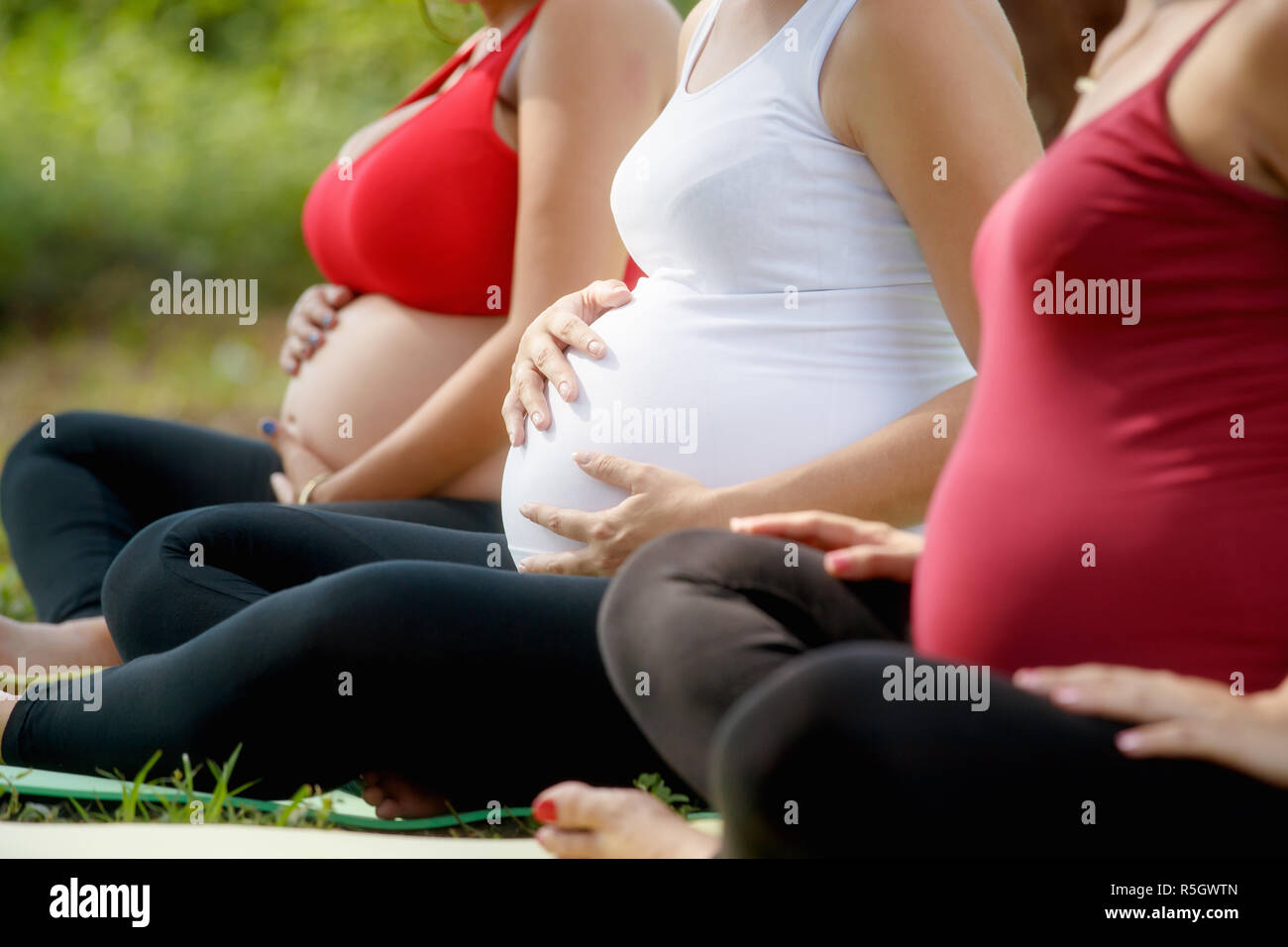 Schwangere Frauen in der Pränatalen Klasse Bauch berühren. Stockfoto