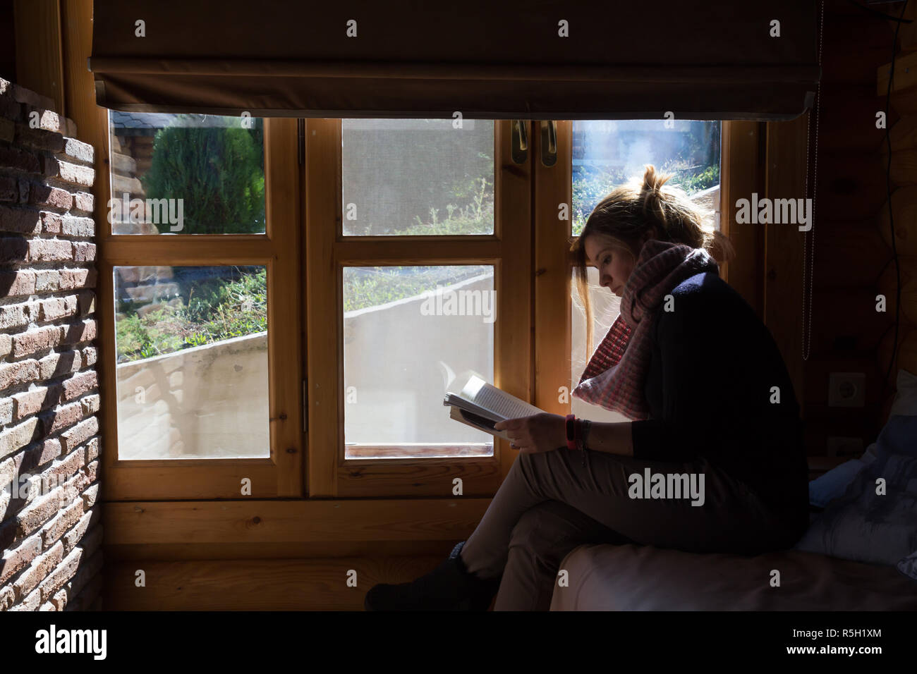 Eine Frau entspannen und lesen ein Buch, während der Ferien Stockfoto