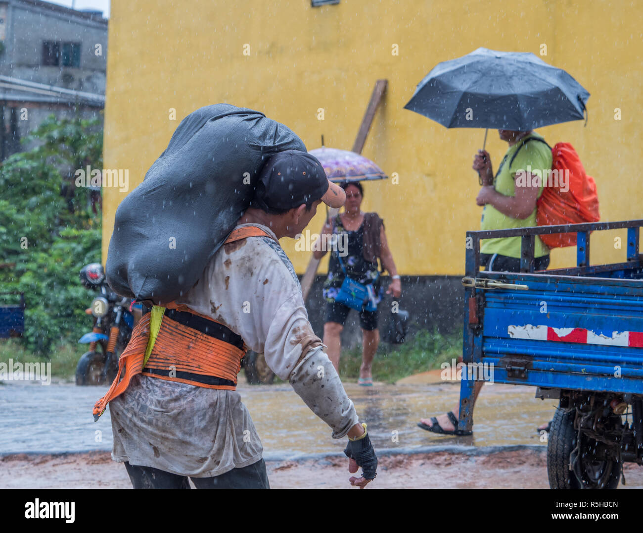 Tabatinga, Brasilien - 15. September 2018: Mann mit schwarzer Beutel voller Früchte während eines regnerischen Tag im Hafen des Amazonas. Tres Fronteras. Lateinamerika. Stockfoto