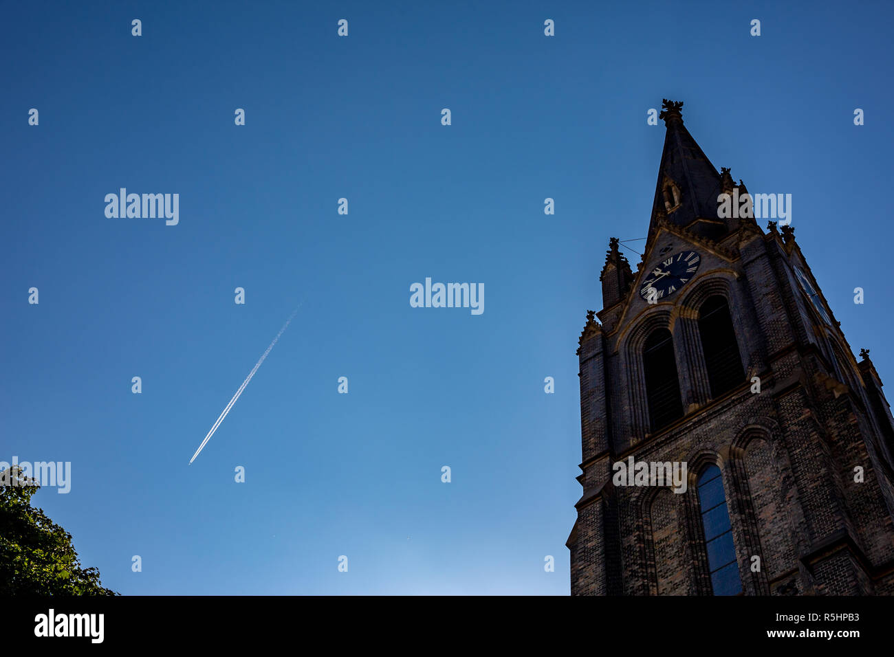 Blauer Himmel mit dem Flugzeug Trail und die Vorderseite der Kathedrale im gotischen Baustil mit Uhrturm in der Altstadt von Prag, Tschechische Republik Stockfoto