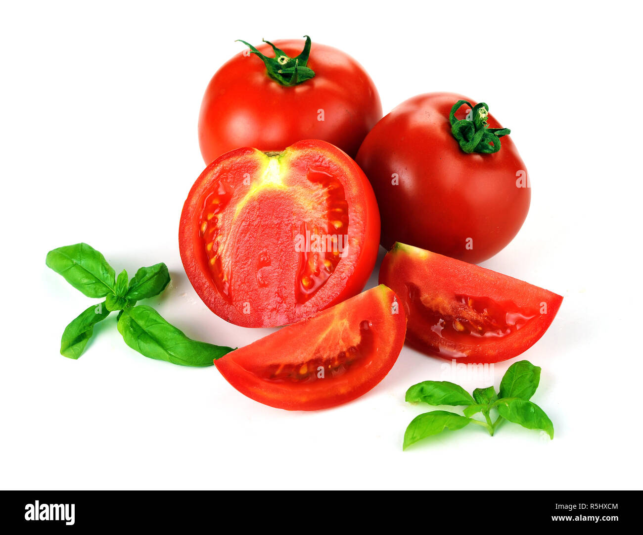 Frische reife Tomaten, saftig grüne Basilikumblätter auf weißem Hintergrund. Gesunde natürliche Lebensmittel aus biologischem Anbau, Ernte und italienisch Kochen Konzept Stockfoto