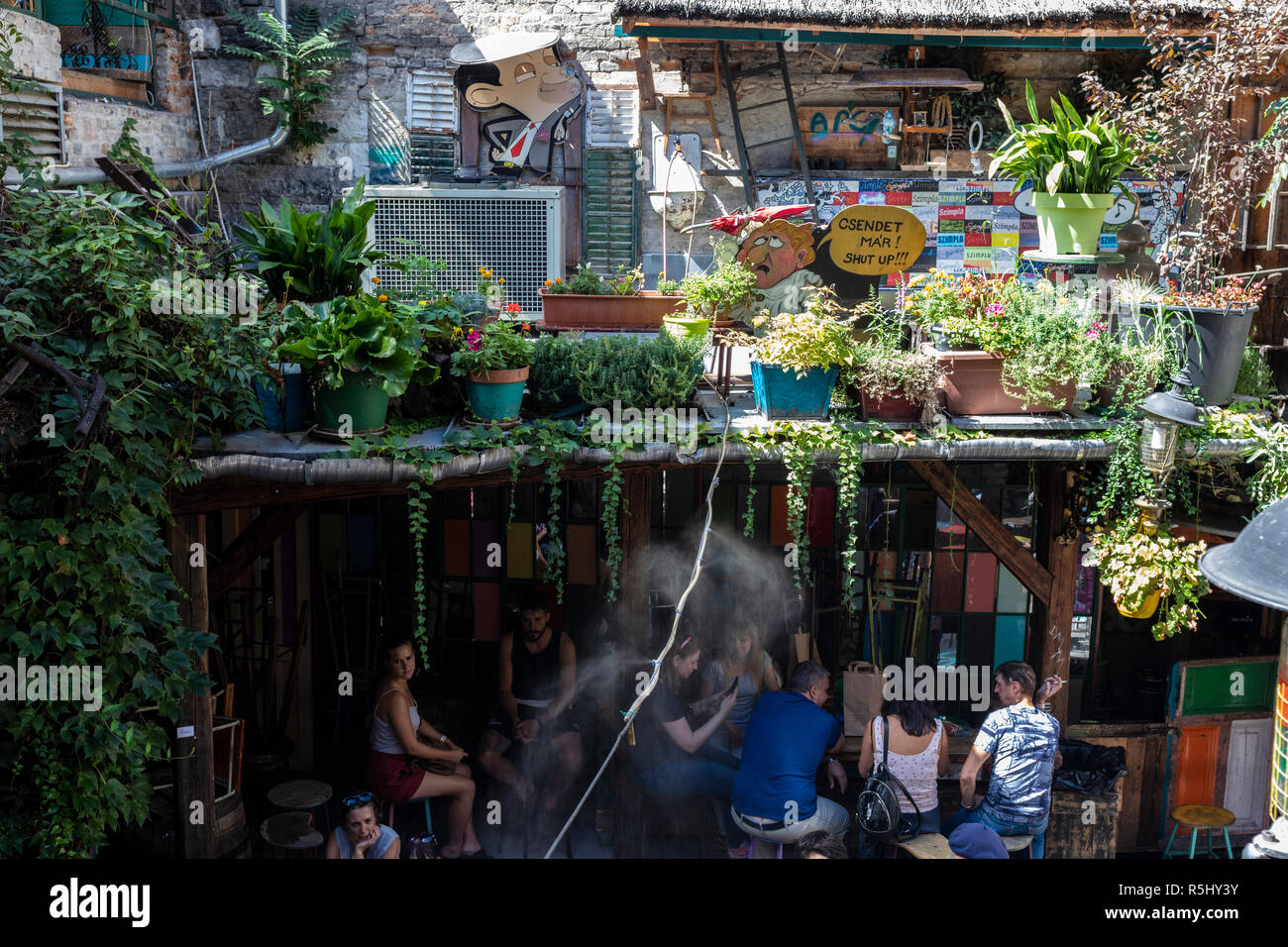 BUDAPEST, Ungarn - 12. August 2018: Touristen unter einem Dach sitzen an einem heißen sonnigen Tag im Szimpla Kert ruine Pub und Farmers Market, einer der beliebtesten Stockfoto