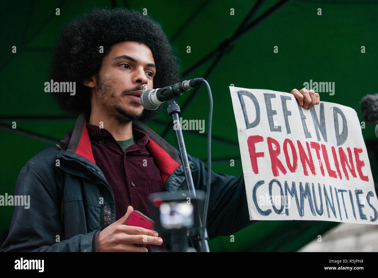 London, Großbritannien. 1. Dezember, 2018. Ein Sprecher von globaler Gerechtigkeit nun den Zusammen für Klimagerechtigkeit Demonstration gegen die Politik der Regierung in Bezug auf den Klimawandel, einschließlich Heathrow Expansion und Fracking. Nach einer Kundgebung vor der polnischen Botschaft, gewählt werden, um die UNO Katowice Klimawandel Konferenz, die morgen beginnt, Demonstranten, Downing Street marschierten. Credit: Mark Kerrison/Alamy leben Nachrichten Stockfoto