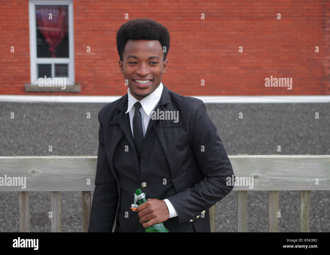 Geschäftsmann, Lächeln, Wein trinken Holding Flasche außerhalb Stockfoto