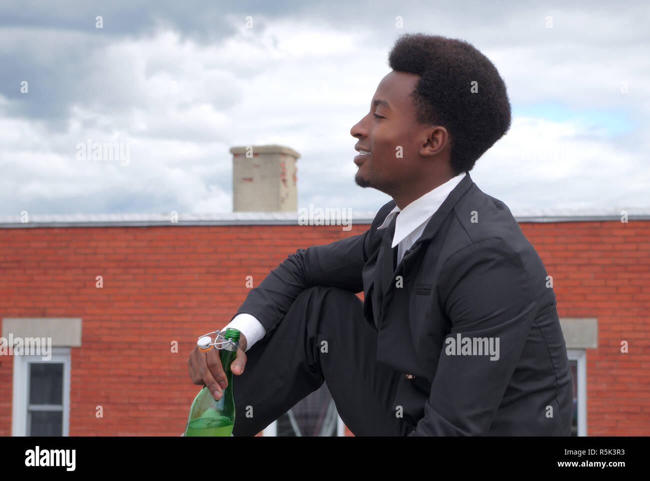Junge Unternehmer, Wein trinken Flasche im Freien sitzen und Lächeln Stockfoto