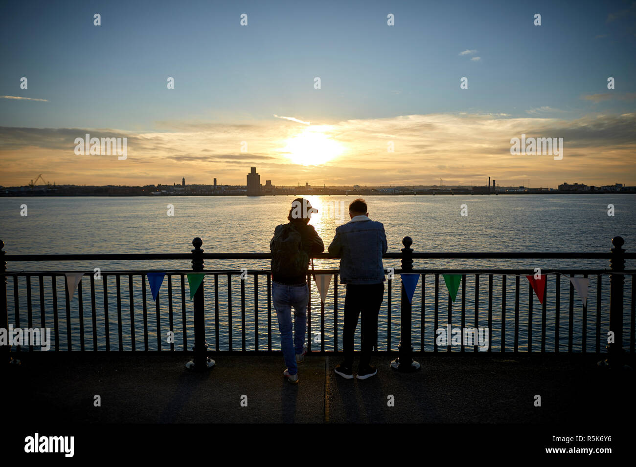 Pier Head Liverpool Waterfront mit Blick über den Fluss Mersey in Birkenhead bei Sonnenuntergang Stockfoto