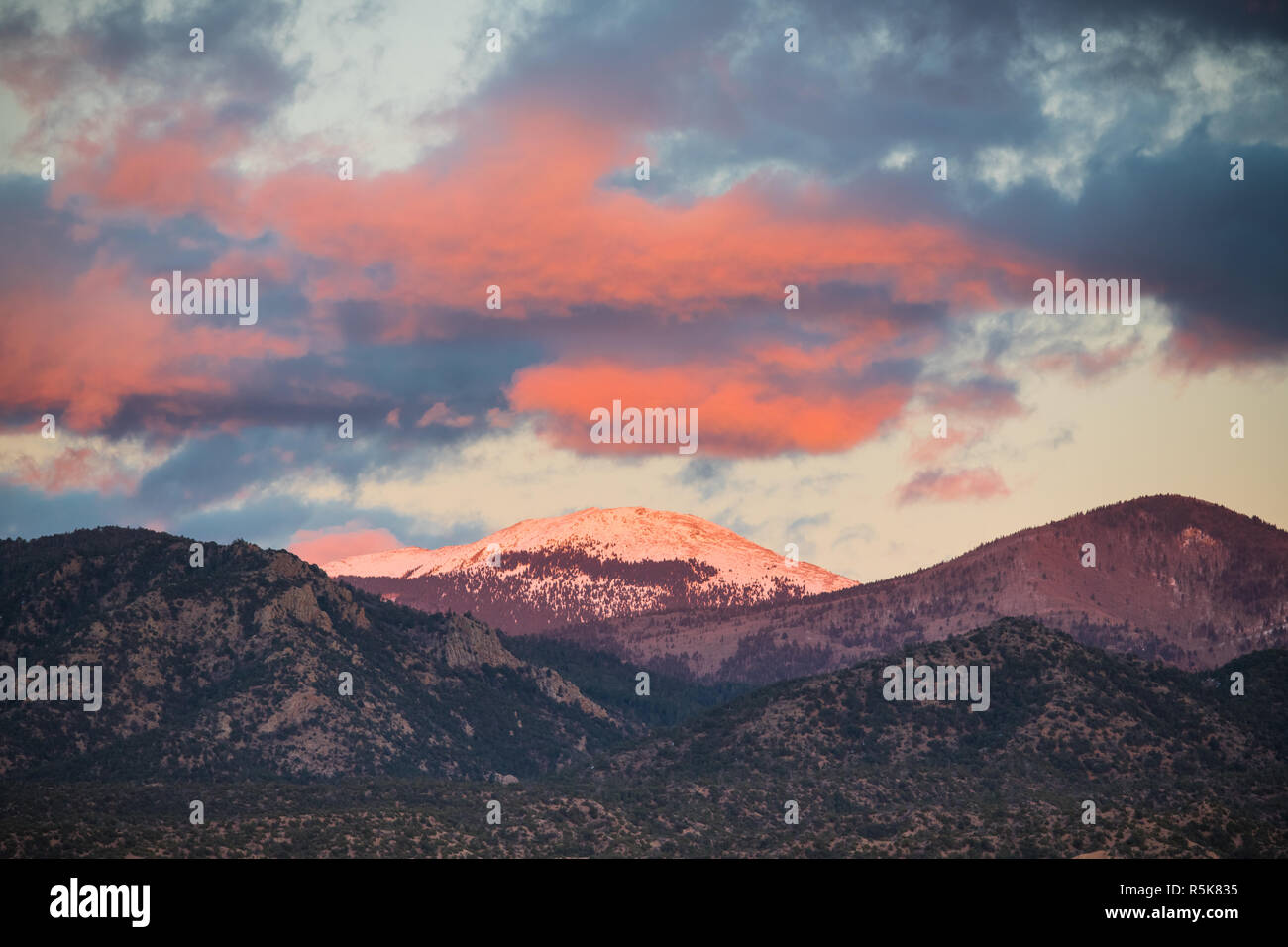 Dramatischer Sonnenuntergang und Wolken über die schneebedeckten Gipfel von Santa Fe Baldy in der Sangre de Cristo Mountains in der Nähe von Santa Fe, New Mexico Stockfoto