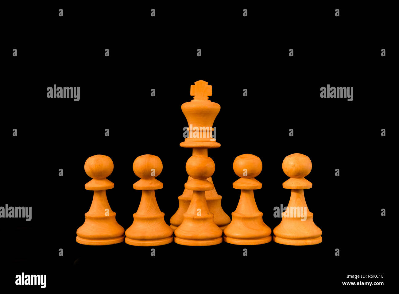 Weiße König durch die Wand der Bauern mit Sinn für den Schutz und die Verteidigung geschützt, Standard Schach Holzstück auf schwarzem Hintergrund Stockfoto