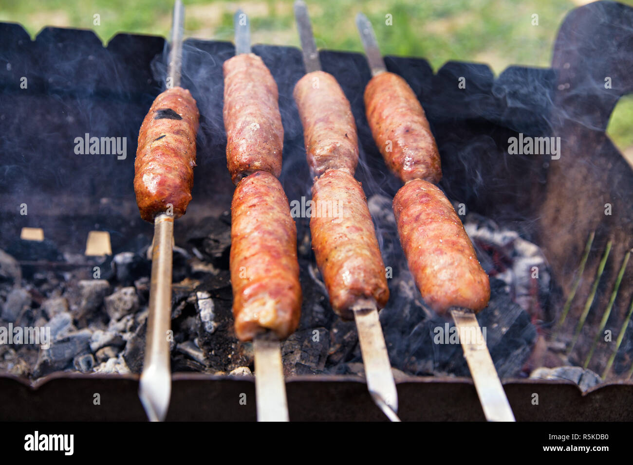 Outdoor Würstchen grillen. BBQ auf brazier. Stockfoto