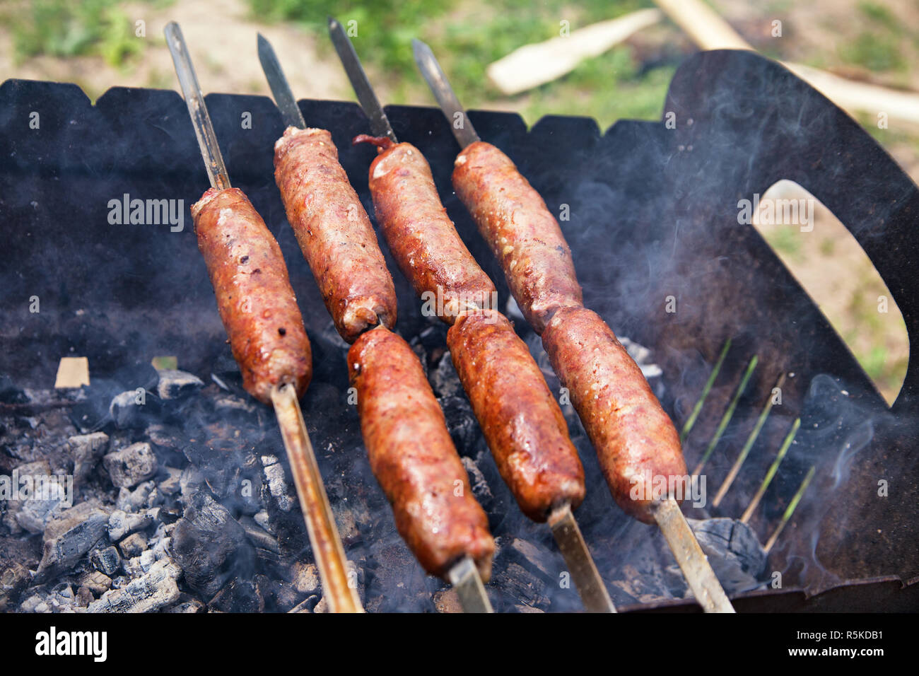 Rind Würstchen gegrillt auf Kohlen. Barbecue auf brazier. Stockfoto