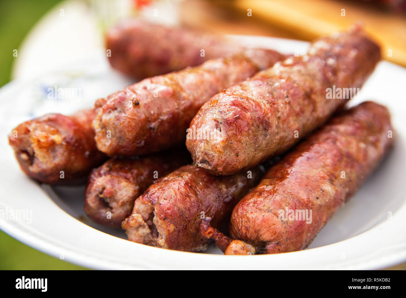 Leckere Würstchen auf Platte auf dem Grill zubereitet. Stockfoto