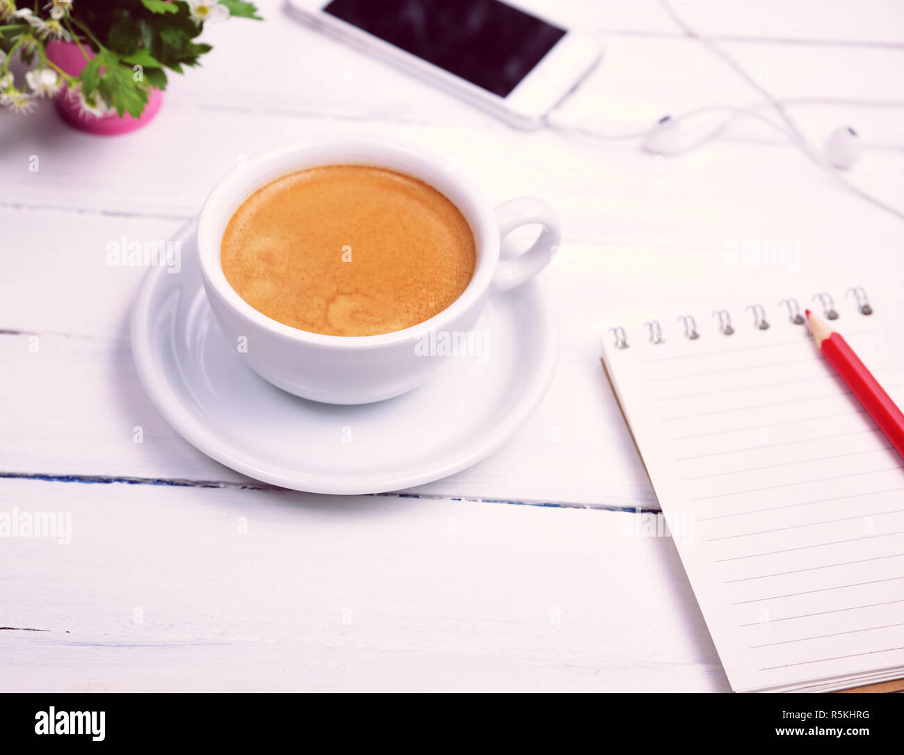 Tasse Kaffee und ein leeres Notizbuch aus Papier Stockfoto