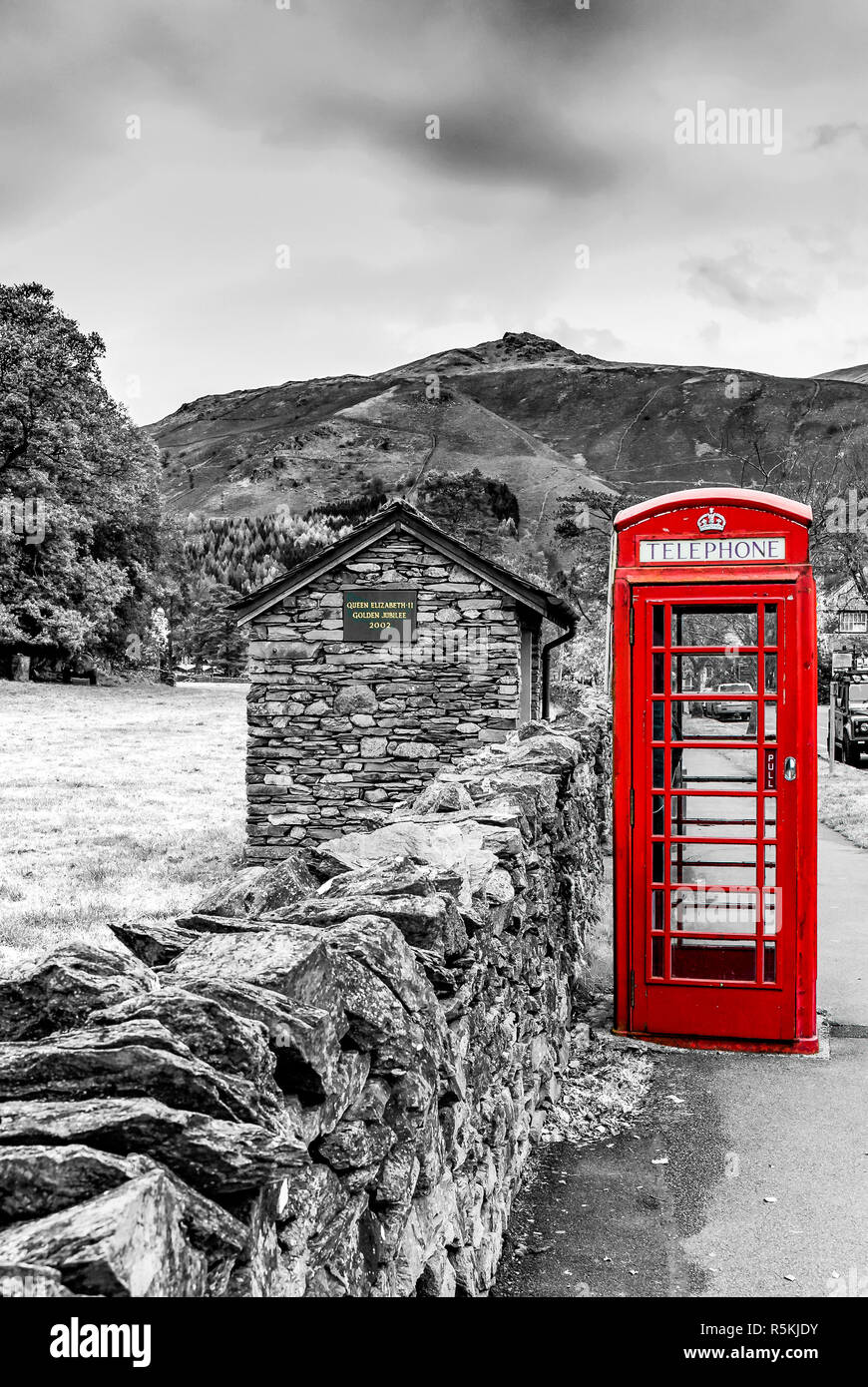 Rote Telefonzelle auf monochromen Hintergrund in Grasmere Dorf im englischen Lake District Stockfoto