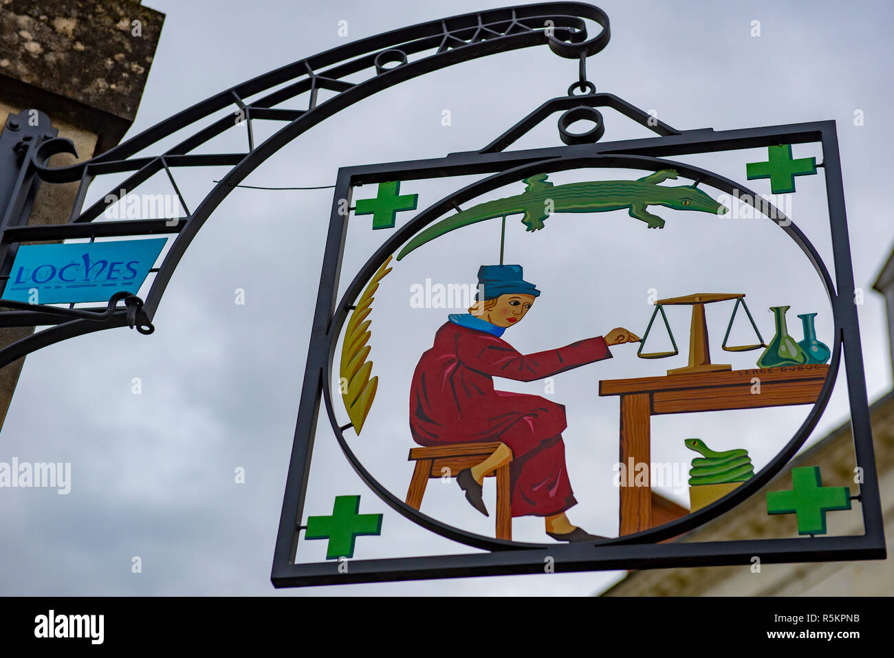 Antike Apotheke Zeichen im ländlichen Frankreich mit Apotheker, Scale, grüne Kreuze, Schlangen und Echsen alle Symbole des Berufs. Stockfoto